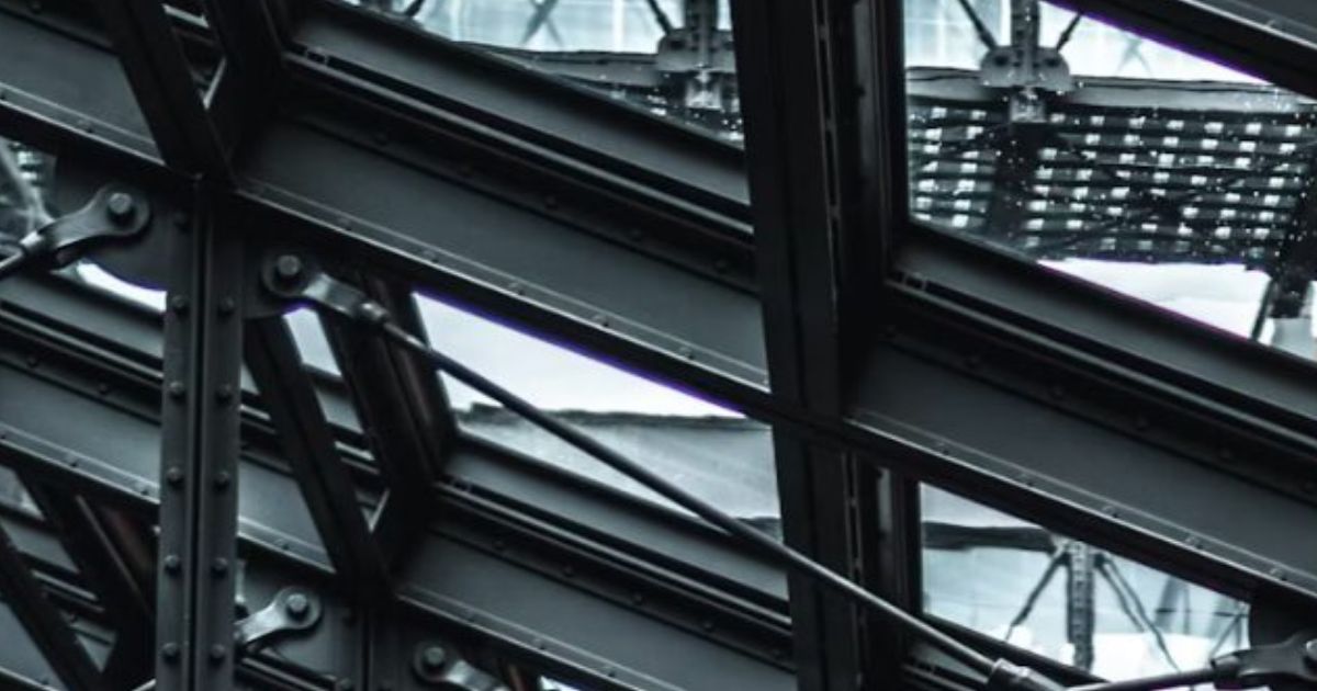 Black steel beams and a glass roof in an industrial building